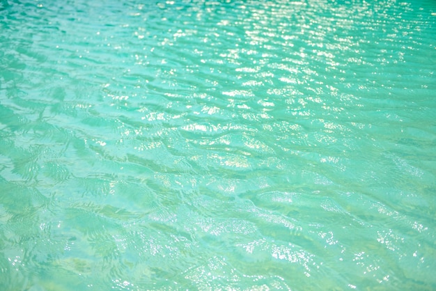 Eau bleue de la piscine avec un effet de réflexion des vagues et de la lumière du soleil