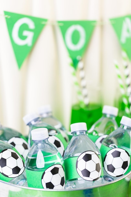 Photo eau en bouteille dans un plateau en métal avec de la glace pour une fête de football.