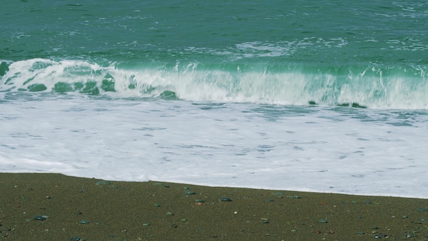 L'eau chaude de la mer l'eau vide de la plage les vagues s'écrasent sur la rive les vagues de la mer surfent sur la plage encore