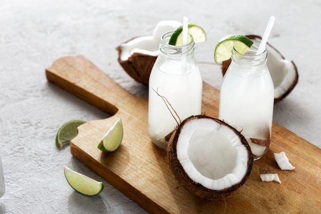 L'eau de coco en bouteilles sur table en bois. Boisson végétarienne saine