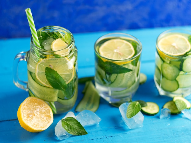 Eau de concombre Detox au citron et à la menthe sur une table bleue en bois