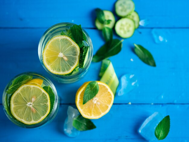 Eau de concombre Detox au citron et à la menthe sur une table bleue en bois