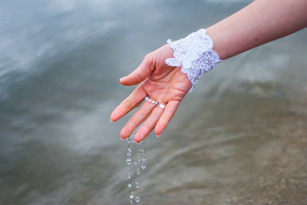 L'eau dégouline des mains d'une mariée dans une rivière