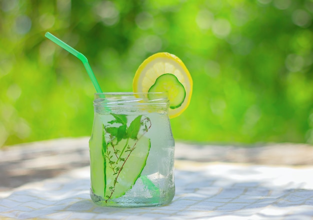 Eau de désintoxication au concombre infusée avec de la glace. boisson d'été rafraîchissante sur la table dans le jardin.