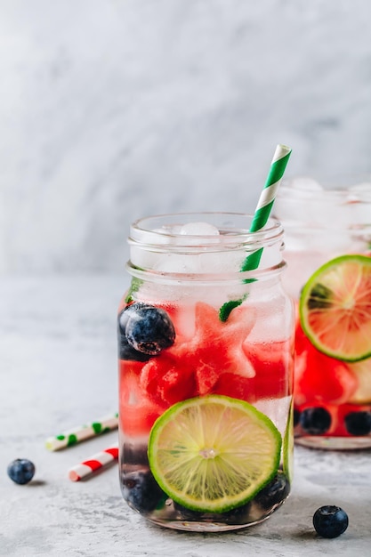 Eau détox infusée avec citron vert pastèque et myrtille Cocktail d'été glacé ou limonade dans un bocal en verre