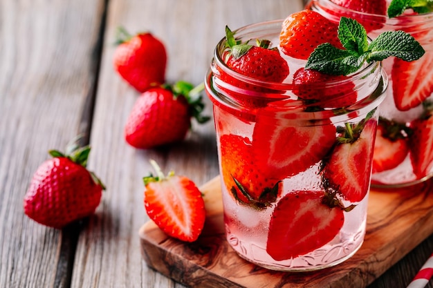 Eau détox infusée à la fraise et à la menthe Cocktail d'été glacé ou limonade dans un bocal en verre