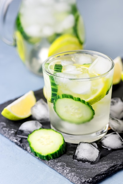 Eau détox infusée froide et rafraîchissante au citron vert et concombre dans un verre avec glaçon