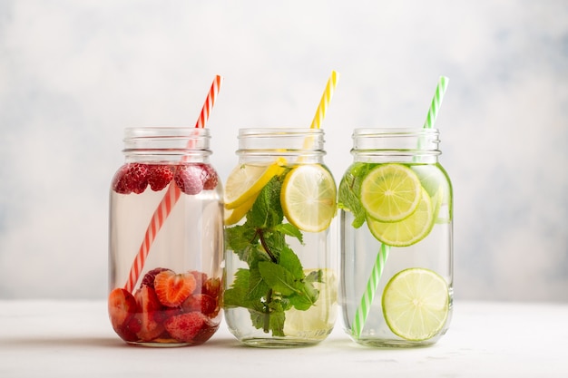 Eau détox en trois pots avec framboises, citron, citron vert et menthe