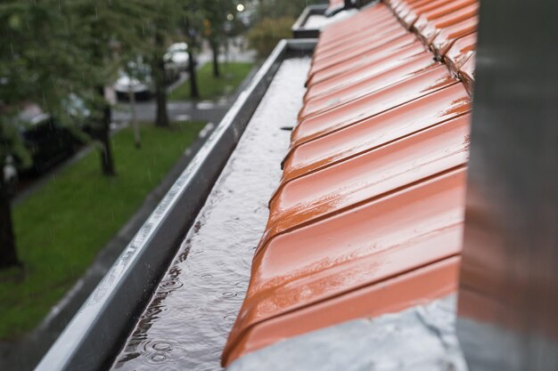 Photo l'eau du toit s'écoule dans la gouttière de drainage par temps pluvieux