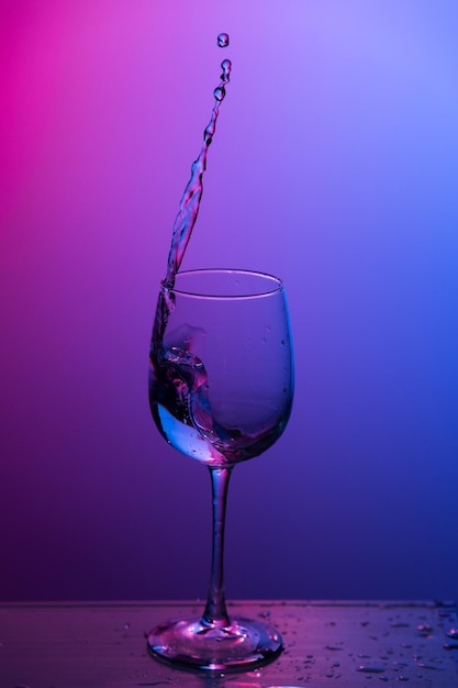 L'eau éclabousse d'un verre à vin.