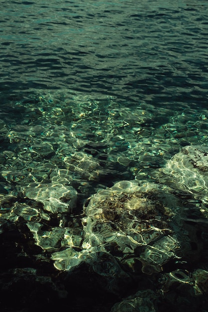 L'eau est claire et le soleil brille sur les rochers.