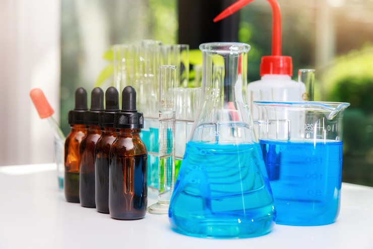 Photo eau expérimentale bleue dans un bécher et une fiole dans un laboratoire de sciences chimiques. groupe de flacons de laboratoire avec liquide à l'intérieur. les chercheurs développent des vaccins et des médicaments pour traiter le virus covid-19.