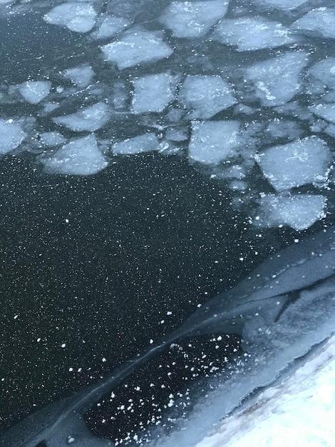 Photo une eau avec des glaçons et un bateau flottant dessus.