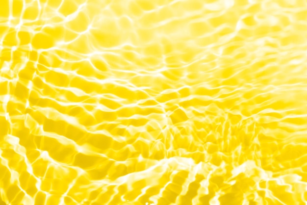 Eau jaune avec des ondulations à la surface Défocalisation floue eau calme transparente de couleur dorée transparente