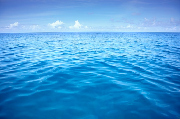 Photo eau de mer bleu profond avec des nuages ​​blancs sur le ciel