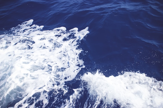 Eau de mer bleue avec écume de mer en arrière-plan. Eau de mer d'un bleu profond avec spray. Fond d'eau de mer.