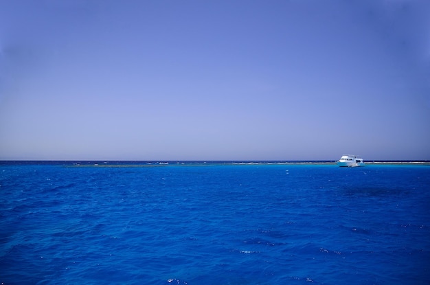 Eau de mer bleue et navire au récif corallien