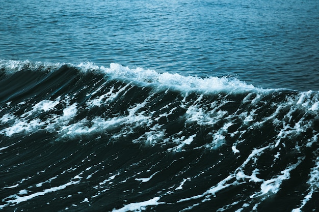 Photo eau de mer bleue avec vague blanche pour le fond.