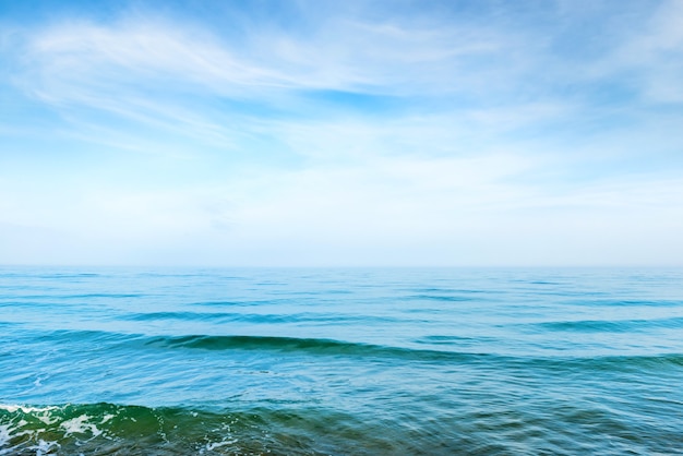 Eau de mer bleue avec des vagues et des nuages blancs dans le ciel. Paysage tropical calme