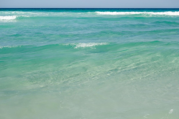 eau de mer claire et peu profonde sur la plage tropicale. Les vagues se brisent sur le sable