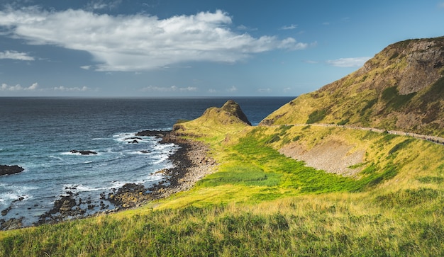 L'eau de mer entourant le rivage de l'irlande du nord paysage marin écrasant le ciel nuageux