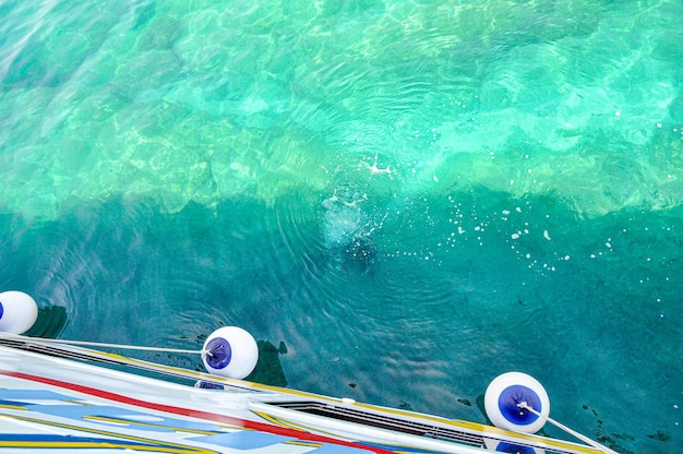 eau de mer turquoise avec une coque du yacht et des ailes