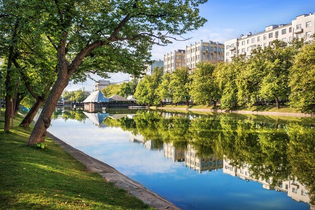 Eau miroir de Chistye Prudy et reflets clairs des maisons et des arbres le long des berges