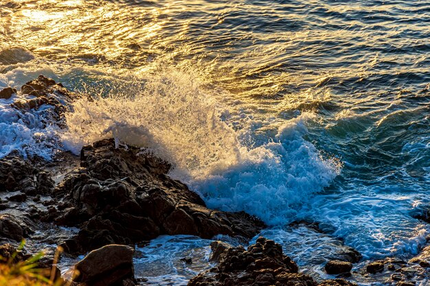 L'eau et la mousse de mer éclaboussant avec le choc des vagues contre les rochers de la ville de Salvador