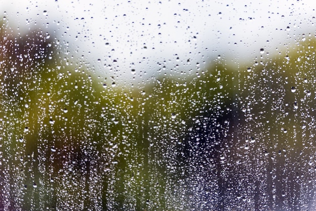 L'eau de pluie tombe sur une surface vitrée. Image flou défocalisé