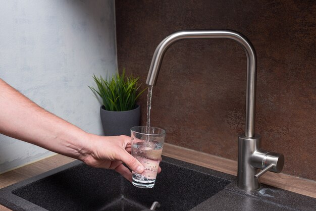 L'eau pure de l'homme en verre à la cuisine moderne