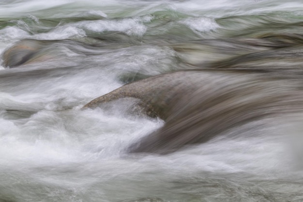 Eau qui coule autour des roches tendres Nature Background