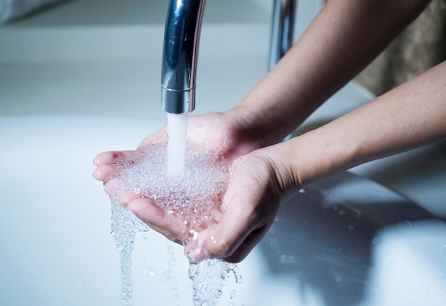 Eau qui coule dans les mains de la femme