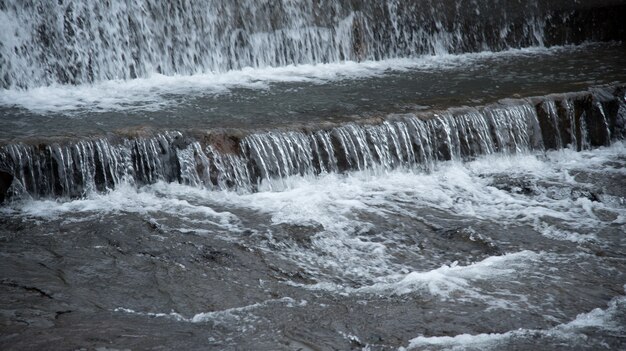 L'eau de la rivière tombant du mur du barrage