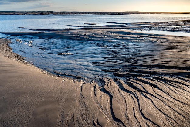 L'eau de ruissellement a creusé des sillons dans le sable à marée basse en Baie de Somme