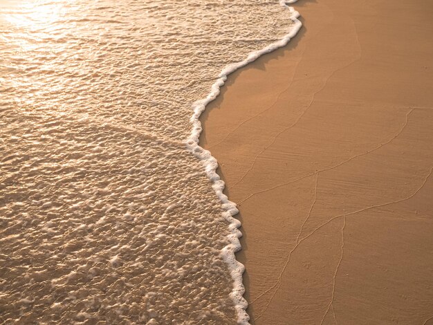 L'eau et le sable sur la plage au coucher du soleil