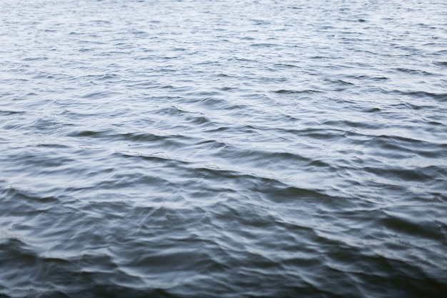 Eau sombre ondulée avec le vent dans le lac.