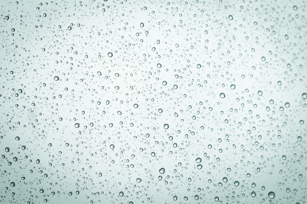 L&#39;eau tombe sur fond de verre de fenêtre.