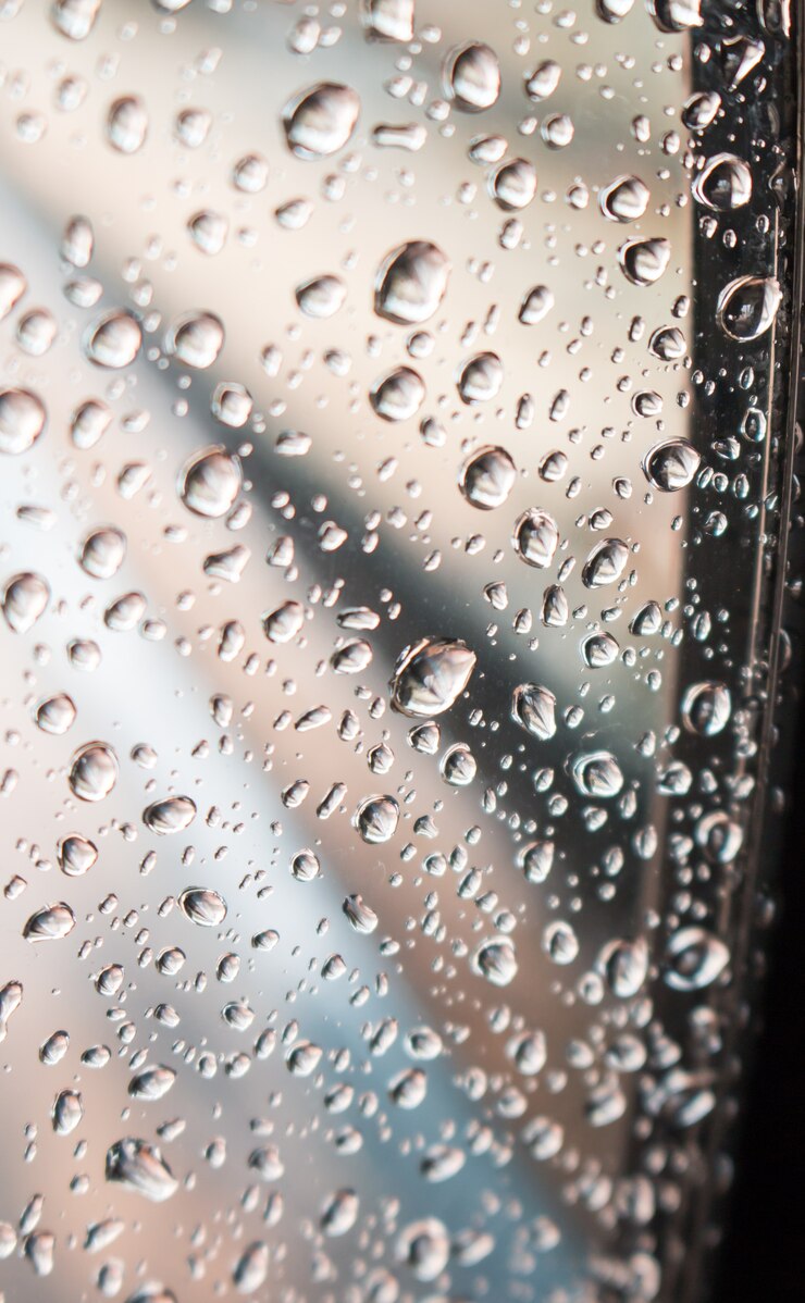L'eau tombe sur fond de verre de fenêtre.