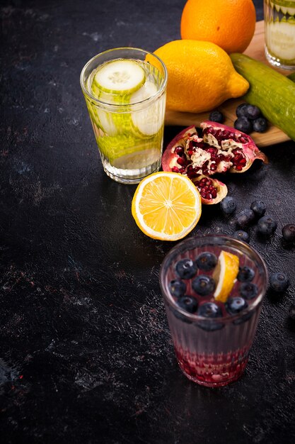 Eau vitaminée maison à partir de différents fruits et légumes sur planche de bois