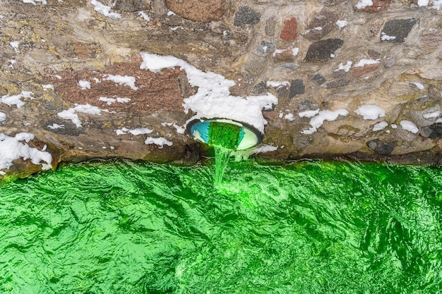 Photo des eaux vertes toxiques s'écoulent des égouts de la ville dans le canal.