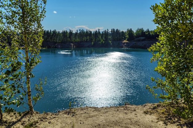 L'éblouissement du soleil sur l'eau La rive escarpée du réservoir