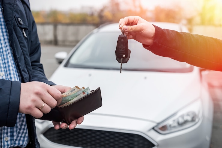 Photo échange de mains avec des clés de voiture et des billets en euros