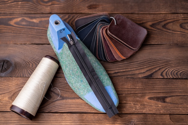 Des échantillons De Cuir Pour Chaussures Et Chaussure En Plastique Durent Sur Une Table En Bois Sombre