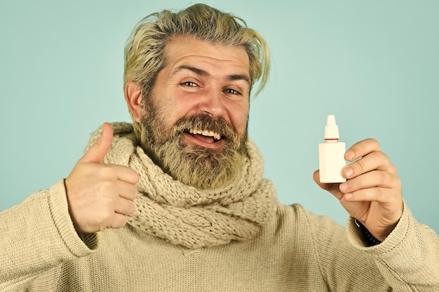 L'écharpe de l'homme tient le spray nasal Récupération efficace des médicaments Traitement médical recommandé Récupération du nez qui coule Concept de soins de santé Récupération rapide Remèdes contre la grippe froide Nez qui coule et symptômes du rhume