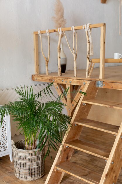 Photo une échelle en bois avec une plante dans le coin à côté.