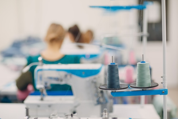 Photo Écheveaux de fil et machine à coudre sur fond de couturières et atelier de couture