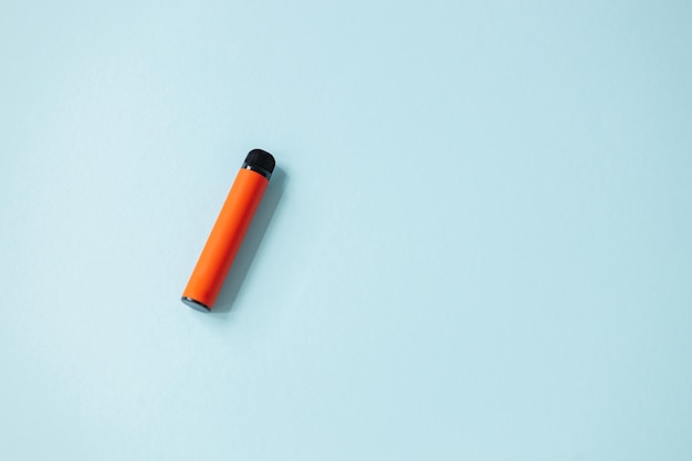 Une ecigarette orange jetable Concept de mauvaises habitudes de fumer des cigarettes électroniques modernes