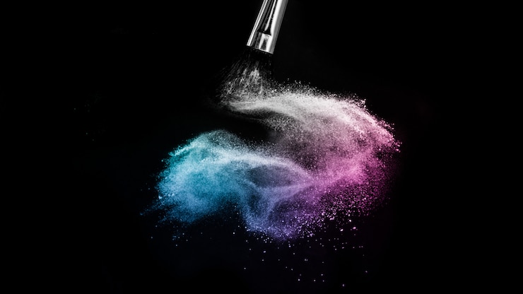 Photo éclaboussure de couleur poudre océan bleu et violet et pinceau pour le maquillage