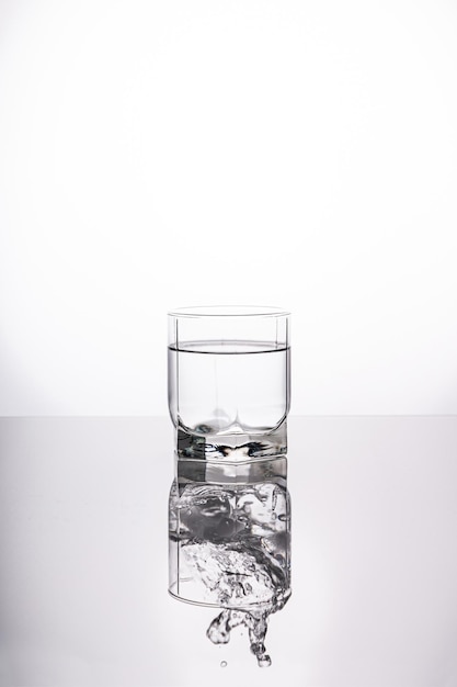 Une éclaboussure d'eau dans un verre sur un fond clair verre d'eau douce avec des bulles fond blanc