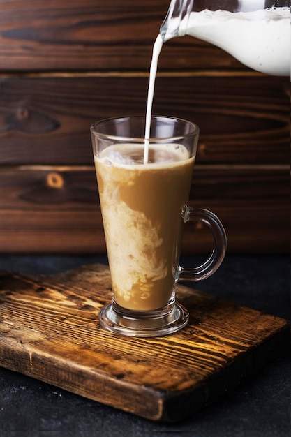 Photo Éclaboussures de café dans un verre sur fond de bois